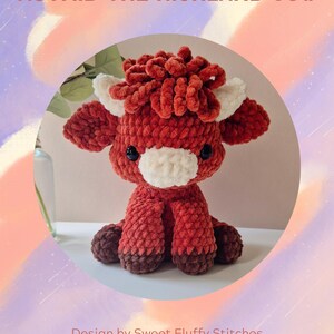 May include: A red and white crocheted Highland cow plush toy with a fluffy brown mane. The toy is sitting on a white surface. Astrid the Highland Cow.