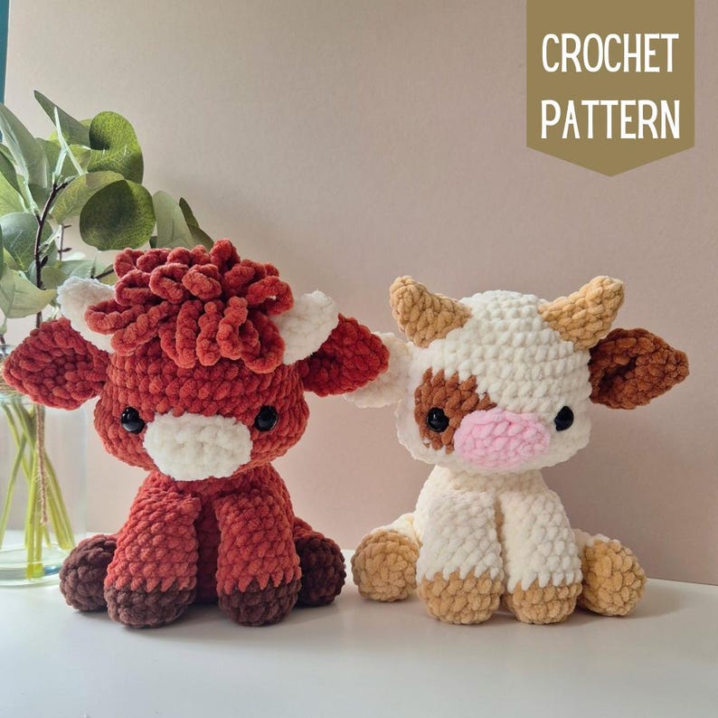 May include: Two crocheted stuffed cows, one brown and one white with brown spots. The brown cow has a fluffy red mane. The white cow has a pink nose. CROCHET PATTERN text is in the upper right corner of the image.