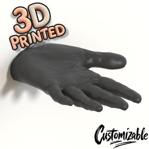Könnte beinhalten: Eine 3D-gedruckte, dunkelgraue Handskulptur, die aus einer weißen Oberfläche herausragt. Die Worte "3D PRINTED" stehen in einer 3D-Schriftart über der Hand, und das Wort "Customizable" ist darunter kursiv geschrieben.