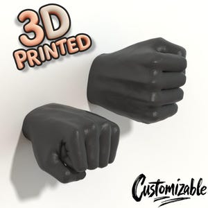 May include: Two 3D printed gray fists, one facing the viewer and the other facing away. The text "3D PRINTED" is in the upper left corner of the image. The text "Customizable" is in the lower right corner of the image.