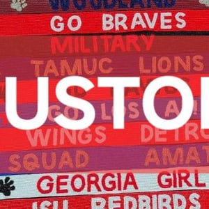 May include: A close-up of a colorful fabric banner with the word "CUSTOM" in white letters. The banner is made up of multiple strips of fabric, each with a different color and text. The text includes team names, slogans, and locations.