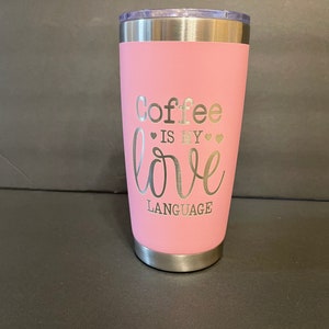 May include: A pink insulated tumbler with a silver lid and base. The text "Coffee is my love language" is etched on the front in silver lettering. The tumbler is designed to keep beverages hot or cold.
