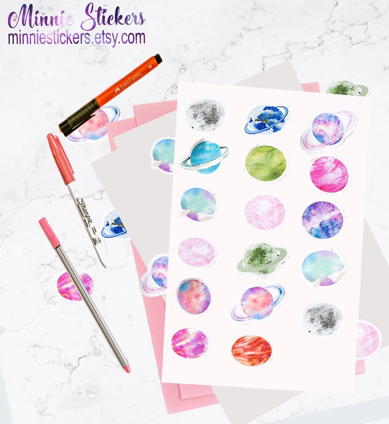 May include: A sheet of stickers featuring watercolour illustrations of planets with rings. The planets are in various colours, including blue, green, pink, purple, and grey. The stickers are perfect for adding a touch of whimsy to your planner, journal, or laptop.