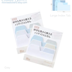 Puede incluir: Un paquete de 60 pesta&ntilde;as de &iacute;ndice de color azul pastel, blanco y beige con el texto "好きな色から使える インデックスふせん" en japon&eacute;s. Las pesta&ntilde;as est&aacute;n en un paquete de pl&aacute;stico transparente con un fondo blanco. El texto "Large Index Tab" est&aacute; impreso en una pesta&ntilde;a azul en la esquina superior derecha de la imagen.