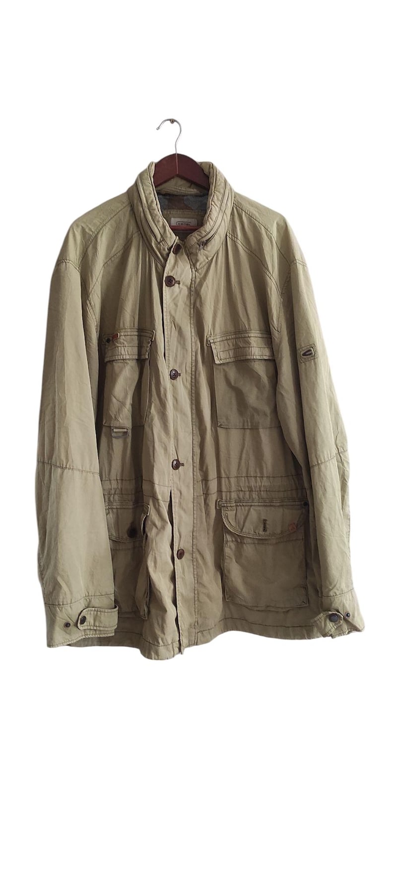 May include: A light brown utility jacket with multiple pockets and a button closure.