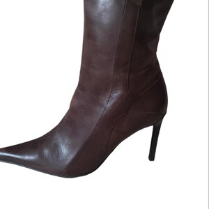 May include: Brown leather ankle boots with a pointed toe and a stiletto heel.