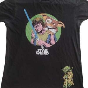 May include: Black t-shirt with a graphic featuring a character with a lightsaber and a creature. The text "STAR WEIRD" is below the graphic. A small Yoda graphic is on the bottom right.
