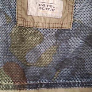 May include: A green camouflage jacket with a brown mesh lining and a white label that says "camel active". The jacket has a black "ANTIC HER" text on the bottom.