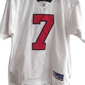 Könnte beinhalten: Weißes Football-Trikot mit schwarzem Kragen und roter Nummer 7. Das Trikot hat ein Netzgewebe und einen NFL-Logo-Patch.