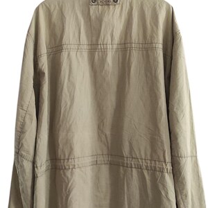 May include: A beige jacket with a brown label on the back that says "The North Face" and a zipper closure.