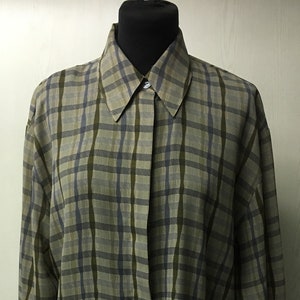 May include: A long-sleeved, button-down shirt with a plaid pattern in shades of green, blue, and beige.
