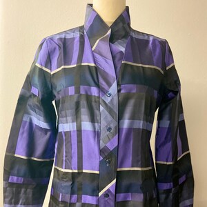 May include: A long-sleeved button-up shirt with a geometric pattern in shades of purple, blue, and black.