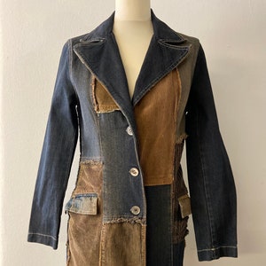 Peut inclure: Une veste en jean à manches longues avec un panneau en velours côtelé et des détails en patchwork. La veste a une fermeture à boutons et deux poches.