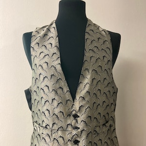 May include: A black and white patterned waistcoat with a V-neck and five buttons. The waistcoat is made of a silky fabric.