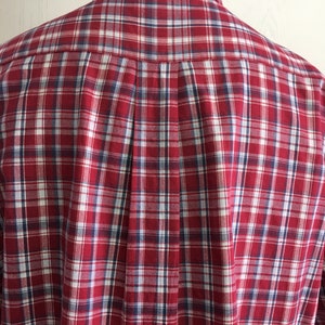 Puede incluir: Camisa de botones a cuadros rojos, blancos y azules. La camisa tiene un corte cl&aacute;sico y un cuello.