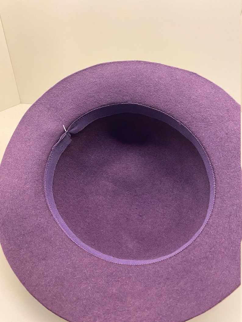May include: Purple felt fedora hat with a purple ribbon around the inside of the brim.