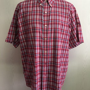 Puede incluir: Camisa de manga corta con botones a cuadros rojos y blancos.
