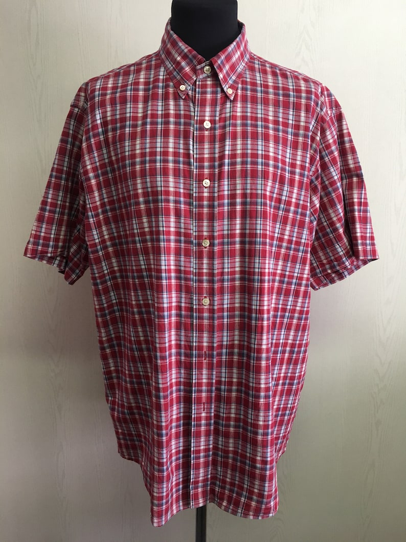 Puede incluir: Camisa de manga corta con botones a cuadros rojos y blancos.