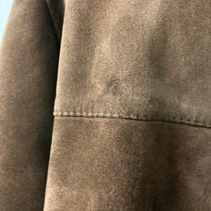 May include: A brown suede jacket with a seam across the back.