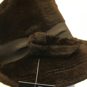 Puede incluir: Un sombrero de piel sint&eacute;tica marr&oacute;n con ala ancha y una cinta marr&oacute;n a juego atada en un lazo en la parte delantera.