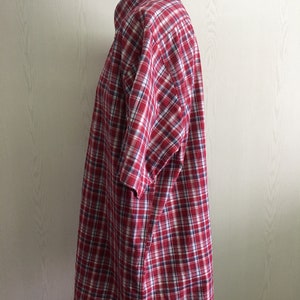 Puede incluir: Camisa de manga corta a cuadros rojos y blancos.