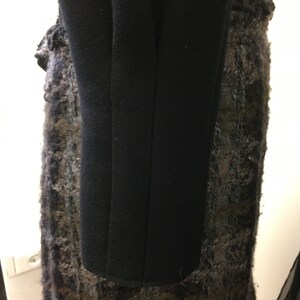 Puede incluir: Abrigo negro de manga larga con forro de tela texturizada.