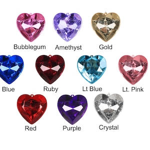 May include: A collection of heart-shaped pendants in various colors, including bubblegum pink, amethyst, gold, blue, ruby red, light blue, light pink, red, purple, and crystal. Each pendant has a faceted design.