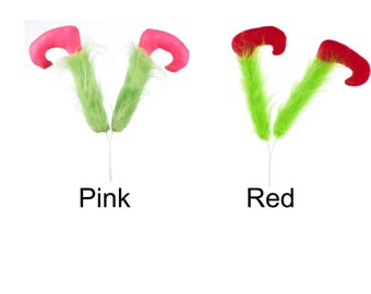 Op de afbeelding: Twee paar elfenoren, een roze en een rode, met een groene, pluche rand.