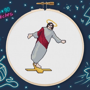 May include: A cross-stitch pattern of a person wearing a robe and a halo, standing on a golden platform. The pattern is framed in a wooden hoop and the text "120x90 stitches" is written in pink and blue letters.