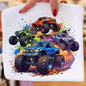 K&ouml;nnte beinhalten: Wei&szlig;es T-Shirt mit einer farbenfrohen Illustration von f&uuml;nf Monstertrucks. Die Trucks sind in Blau, Orange, Gr&uuml;n und Silber dargestellt, mit gro&szlig;en Reifen und detaillierten Designs. Das Design umfasst Farbspritzer und den Text "High Quality PNG / Digital Download".