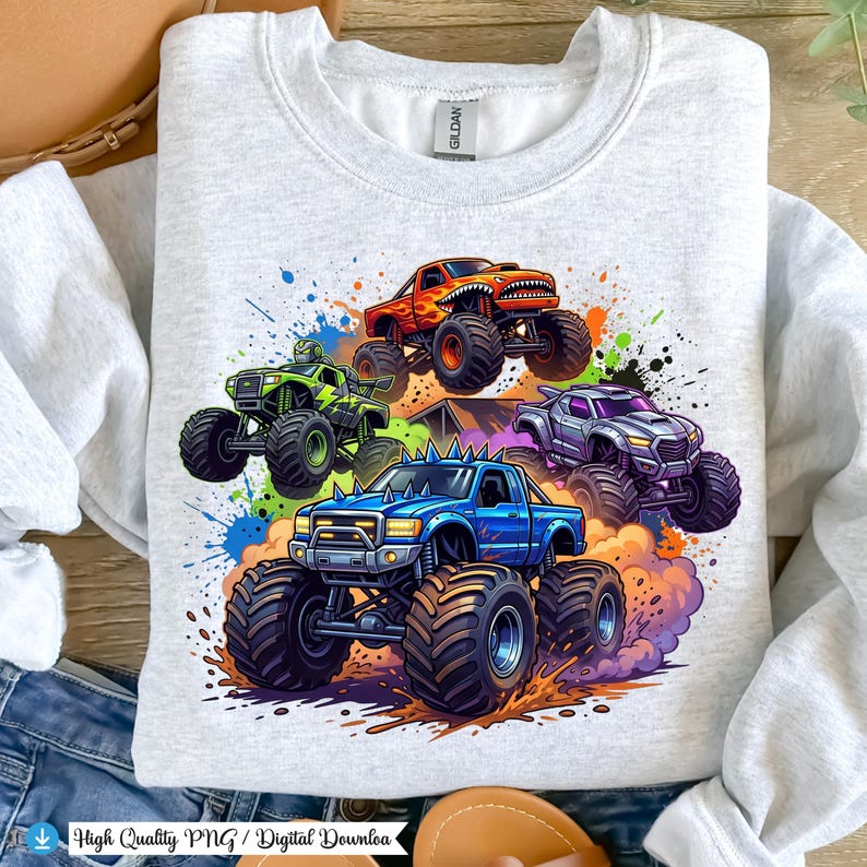 K&ouml;nnte beinhalten: Hellgraues Sweatshirt mit einem farbenfrohen Grafikdesign von f&uuml;nf Monstertrucks in Aktion. Die Trucks sind in verschiedenen Farben dargestellt, darunter Blau, Gr&uuml;n, Orange und Lila, mit gro&szlig;en Reifen und detaillierten Designs. Farbspritzer verst&auml;rken den dynamischen Effekt.