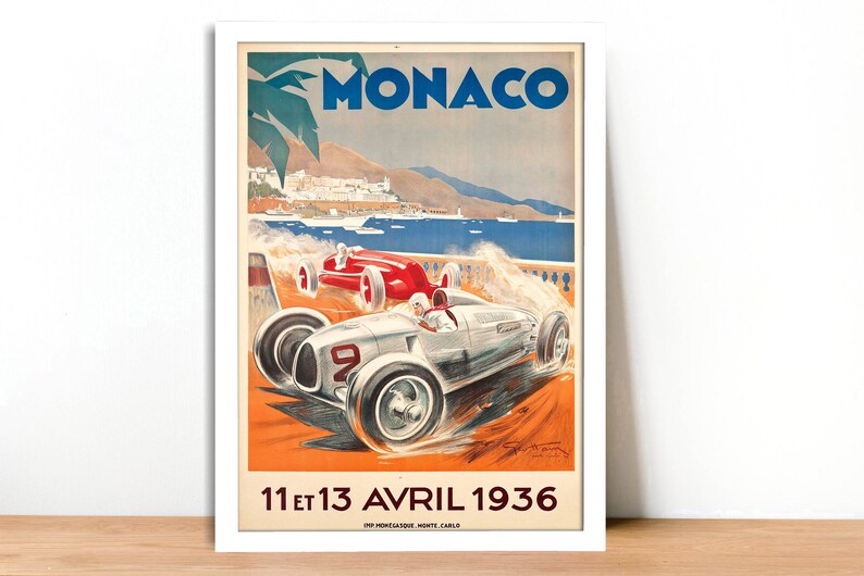 May include: Vintage poster advertising the Monaco Grand Prix, featuring a white and silver race car speeding along a coastal road with a blue ocean and a palm tree in the background. The poster text reads "MONACO" and "11 et 13 AVRIL 1936".