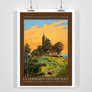 Peut inclure: Une affiche de voyage vintage faisant la publicité de la région pittoresque de Lorraine en France. L'affiche présente une illustration colorée d'une église perchée au sommet d'une colline rocheuse, avec un chemin sinueux qui y mène. Le texte sur l'affiche se lit comme suit : "Chemins de Fer d'Alsace et de Lorraine" et "La Lorraine Pittoresque, Rocher de Dabo, Chapelle S'Leon (Moselle)".