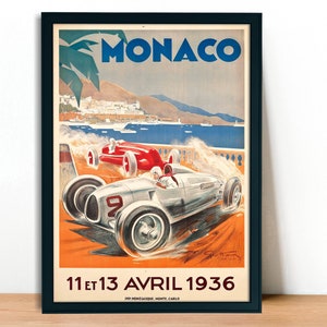 May include: Vintage poster advertising the Monaco Grand Prix, featuring a white and silver race car speeding along a coastal road with a view of the city in the background. The poster is dated "11 et 13 AVRIL 1936" and includes the text "MONACO" in large blue letters.