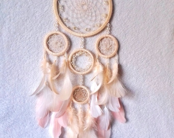 Atrapasueños grande en tonos pastel, cristales y plumas para decorar la pared.
