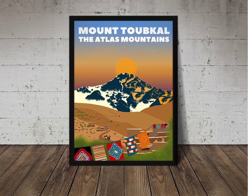 Puede incluir: Un dise&ntilde;o de p&oacute;ster de viaje vintage con el Monte Toubkal, el pico m&aacute;s alto de las monta&ntilde;as del Atlas de Marruecos. El p&oacute;ster tiene una escena de puesta de sol con una cordillera en el fondo y un pueblo en primer plano. Banderas de oraci&oacute;n coloridas cuelgan entre los edificios.