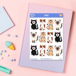 May include: A sheet of stickers featuring nine adorable cartoon kittens in various poses. The stickers are white with a blue border and the text "KITTIES" at the top. The stickers are from the brand "Peach & Mimi" and have the text "@peachandmimi" and "www.peachandmimi.co.uk" at the bottom.