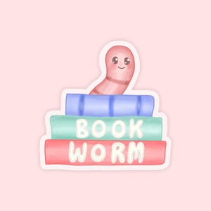 May include: A sticker featuring a cartoon bookworm peeking over a stack of books. The books are blue, green, and red, with the words "BOOK WORM" in white. The bookworm is pink and smiling, set against a light pink background.