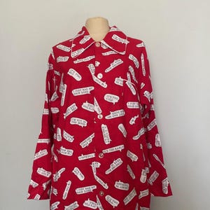 May include: Red button-down shirt with white speech bubbles containing phrases like "It's too early" and "I'm not in the mood." The shirt has a white collar and cuffs. The garment is displayed on a mannequin.