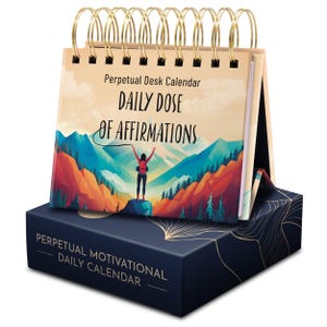 May include: A perpetual desk calendar with a colorful mountain scene and the text "Daily Dose of Affirmations". The calendar has a gold spiral binding and a blue base with gold accents.