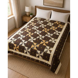 May include: A bed quilt featuring a repeating pinwheel pattern in dark brown, cream, and leopard print fabric. The quilt is accented with small yellow yarn ties at the intersections of the blocks and finished with a solid cream border.