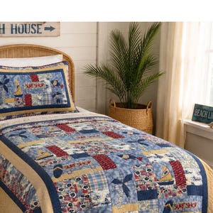 May include: A blue, red, and tan quilt set with a beach theme. The quilt features sailboat, flip-flop, and floral patterns. The pillowcase has a matching design. The words "Surf Shop" are visible on the quilt.