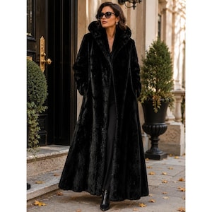 May include: A floor-length black faux fur coat featuring a large hood, long sleeves, and a straight silhouette. The coat is worn over black trousers and is paired with black pointed-toe ankle boots and dark-tinted sunglasses for a cohesive look.