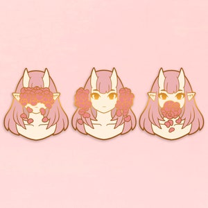 May include: Three gold-colored enamel pins featuring a pink-haired character with horns. The character's eyes are covered by pink flowers in the first pin, the character's mouth is covered by pink flowers in the second pin, and the character's eyes and mouth are visible in the third pin.