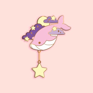 May include: A pink whale with a gold chain and a yellow star charm, flying through purple clouds with gold stars and a yellow moon.