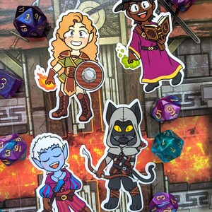 May include: Four illustrated stickers featuring fantasy characters. A female elf warrior with a shield and a sword, a cat-like creature with a hood and a bow and arrow, a female wizard with a pointed hat and a spell book, and a male elf bard with a lute.