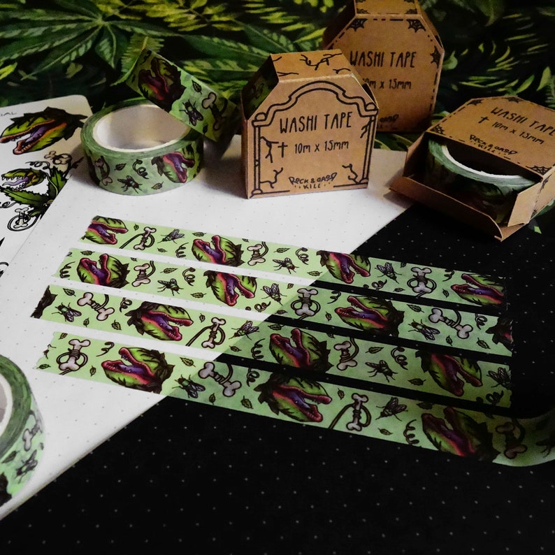 Op de afbeelding: Vier rollen groene en zwarte washi tape met een grafische print van een vleesetende plant. De tape is verpakt in bruine dozen met de tekst "Washi Tape" en "10m x 13mm".
