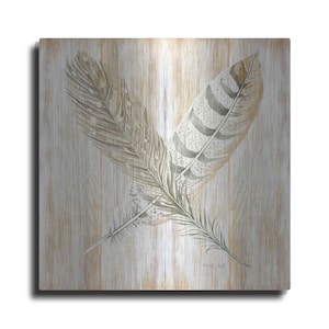 May include: Two gray and brown feathers on a woodgrain background. The feathers are overlapping and have a delicate, intricate pattern.