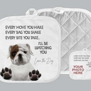 May include: A pair of white oven mitts with a quilted design. One mitt features a cartoon bulldog with the text "Every move you make, every bag you shake, every bite you take... I'll be watching you. Love the Dog". The other mitt has the text "Every move you make, every bag you shake, every bite you take... I'll be watching you. Love the Dog" and the words "Your photo here".