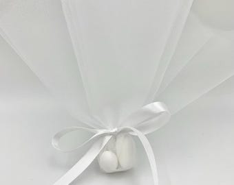 May include: White tulle favour bag with a white satin ribbon tied in a bow. The bag contains white sweets.